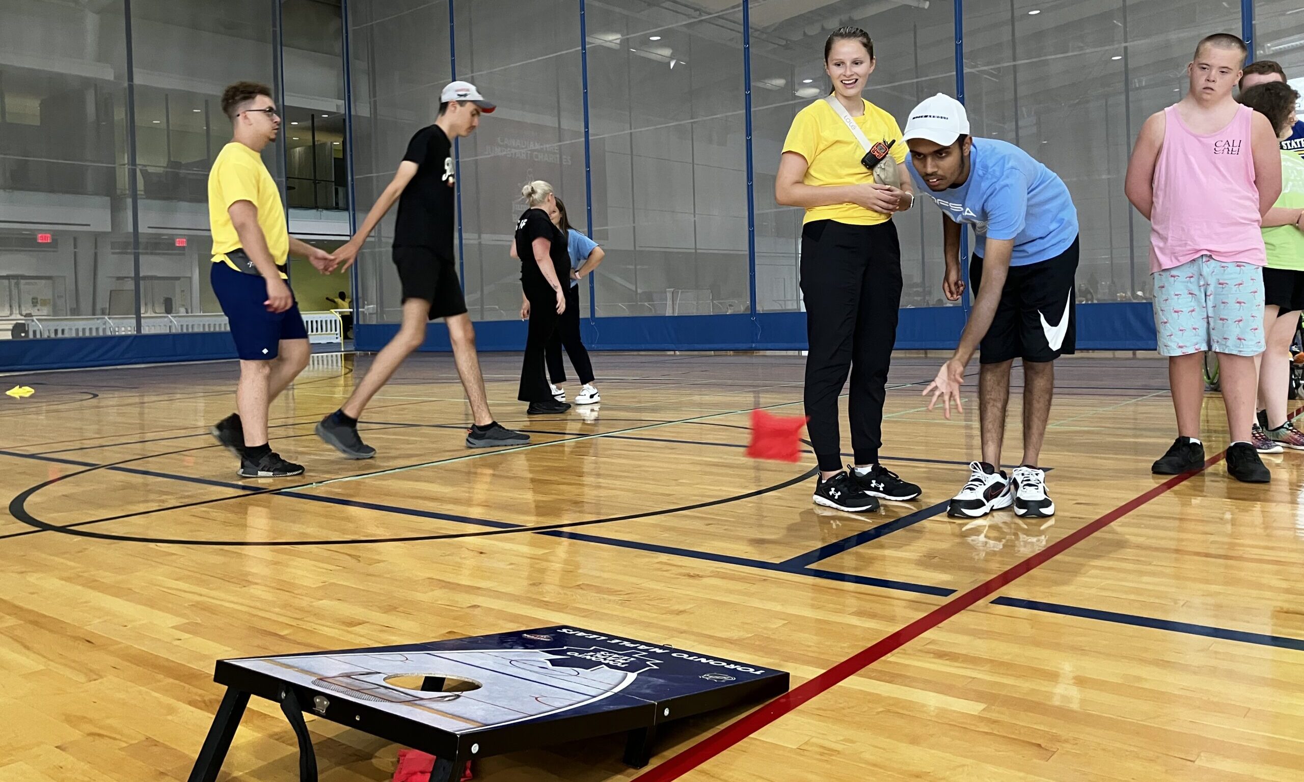 Thrive participants play corn hole on the court.