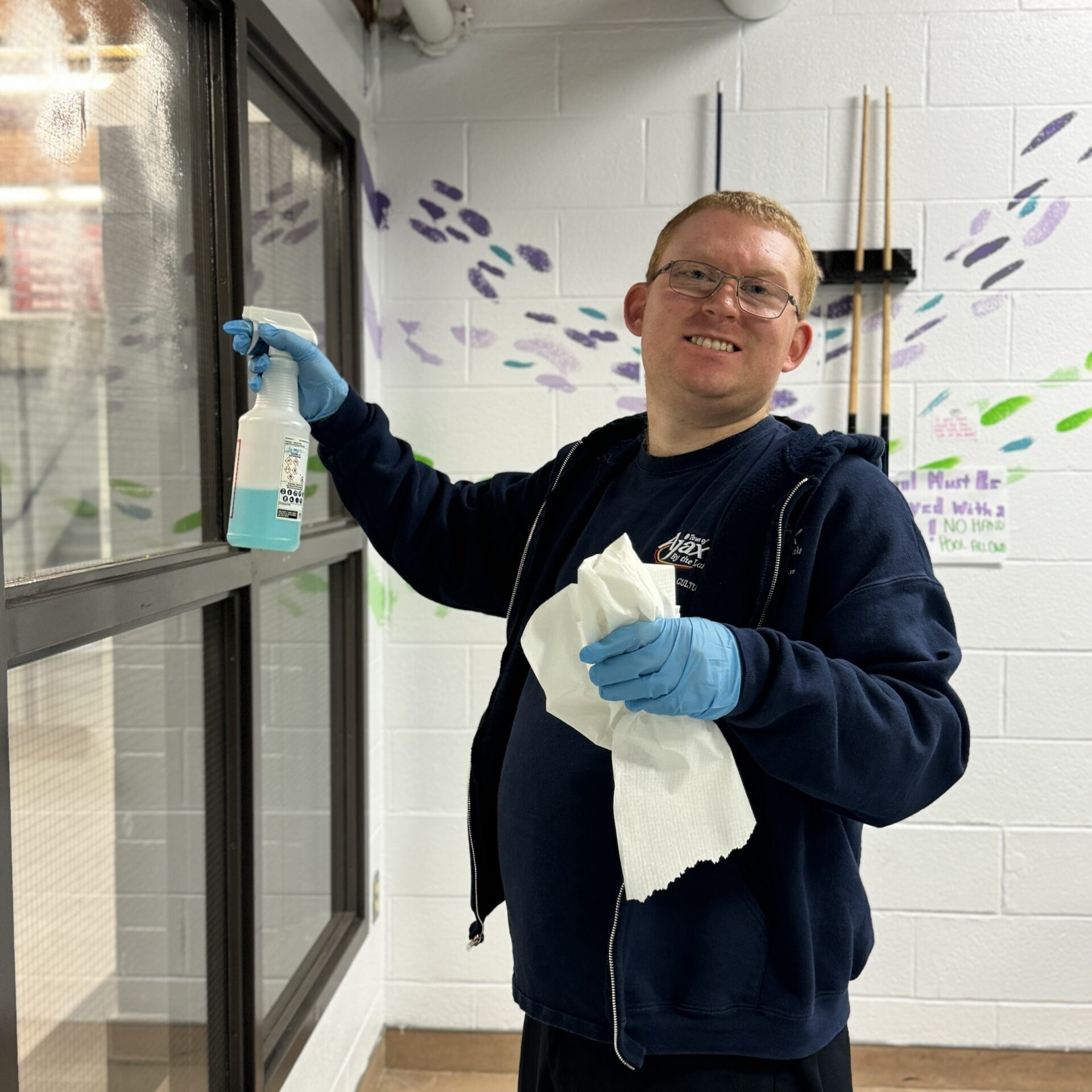 A person smiles while cleaning windows.