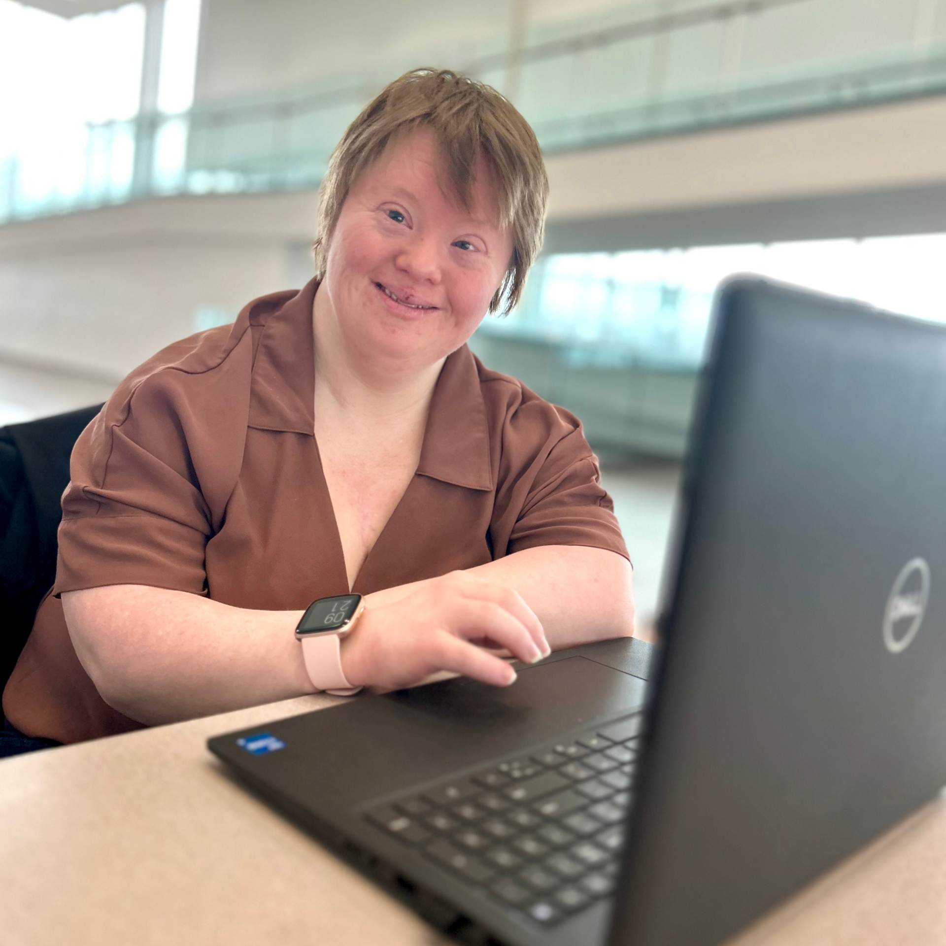 An employment participant smiles while working on her laptop.